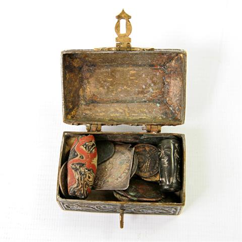 Konvolut: ein Döschen aus Messing mit ornamentaler Gestaltung, darin: ca. zwölf Münzen, ca. zwei Perlen aus Glas/ Stein, ca.